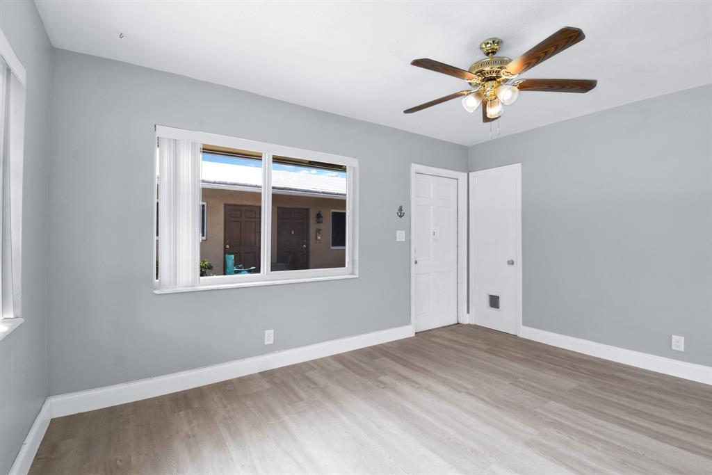 4751 Northeast 21st Terrace, Unit 4 Lighthouse Point, FL 33064 - Photo 7 of 22 a view of a big room with wooden floor and a chandelier fan