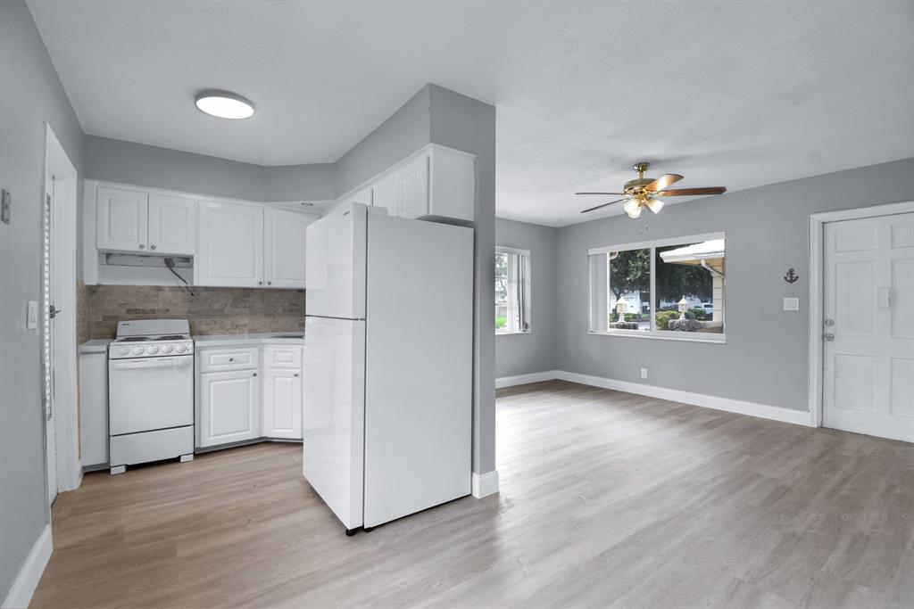 4751 Northeast 21st Terrace, Unit 4 Lighthouse Point, FL 33064 - Photo 9 of 22 a kitchen with white cabinets and wooden floor