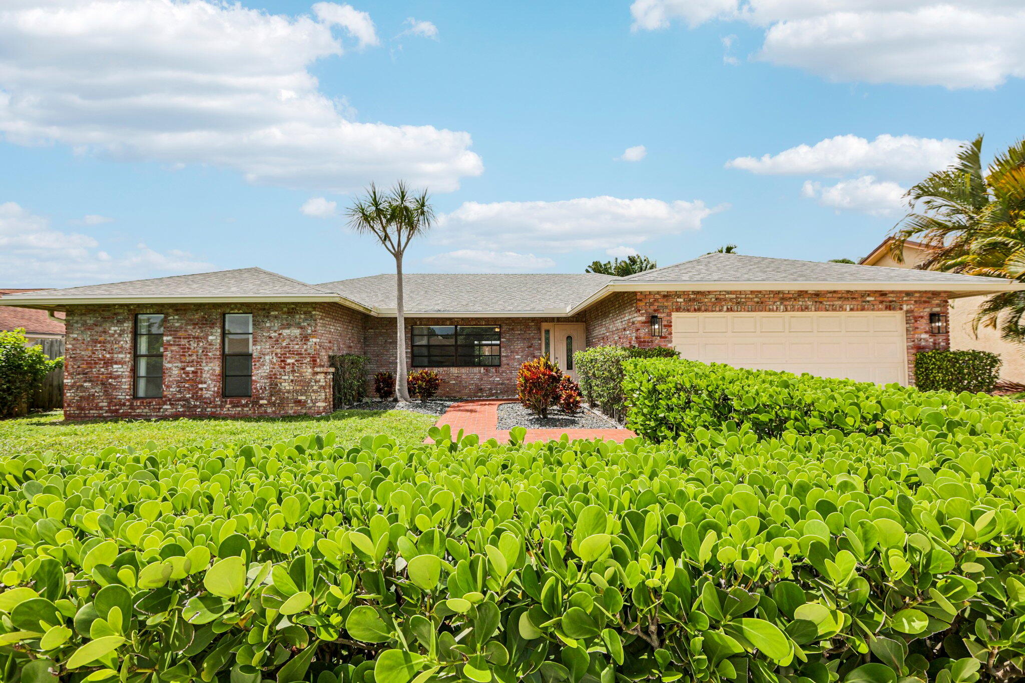 a front view of a house with a big yard and potted plants