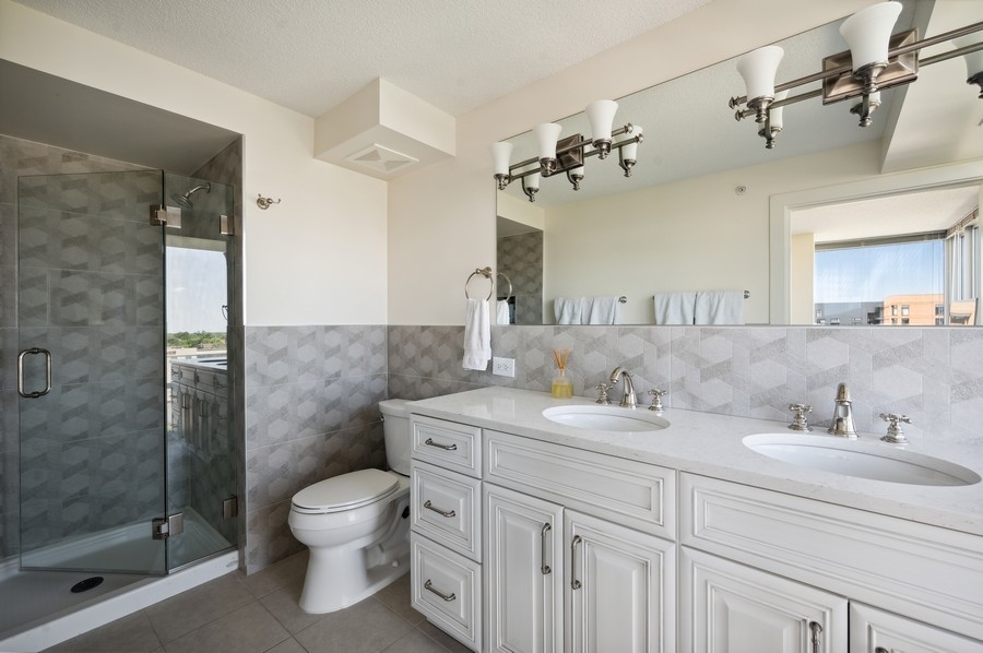 800 Elgin Road, Unit 1001 Evanston, IL 60201 - Photo 16 of 18 a bathroom with a granite countertop sink a toilet and shower