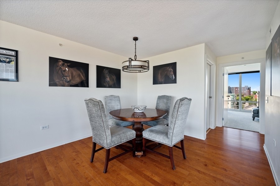 800 Elgin Road, Unit 1001 Evanston, IL 60201 - Photo 9 of 18 a view of a dining room with furniture wooden floor and chandelier