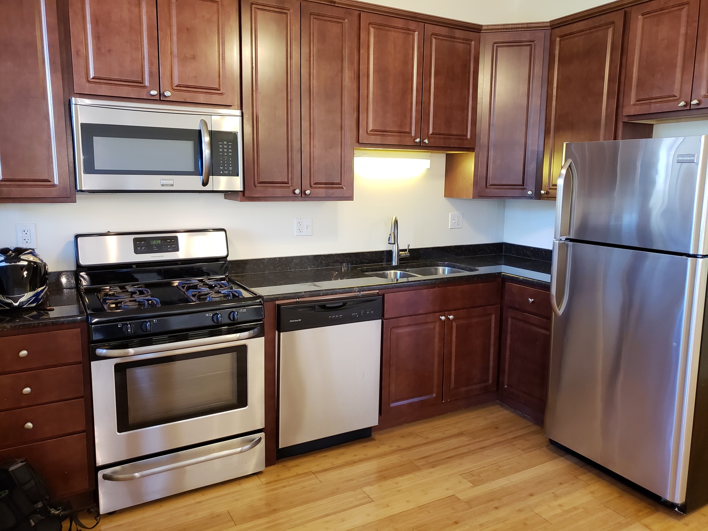 54 East 50th Street, Unit 1 Chicago, IL 60615 - Photo 14 of 27 a kitchen with granite countertop wooden cabinets and stainless steel appliances
