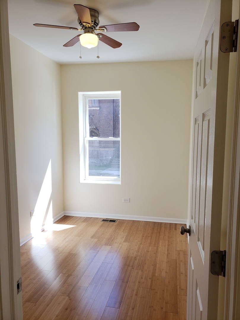 54 East 50th Street, Unit 1 Chicago, IL 60615 - Photo 5 of 27 wooden floor in an empty room with a window