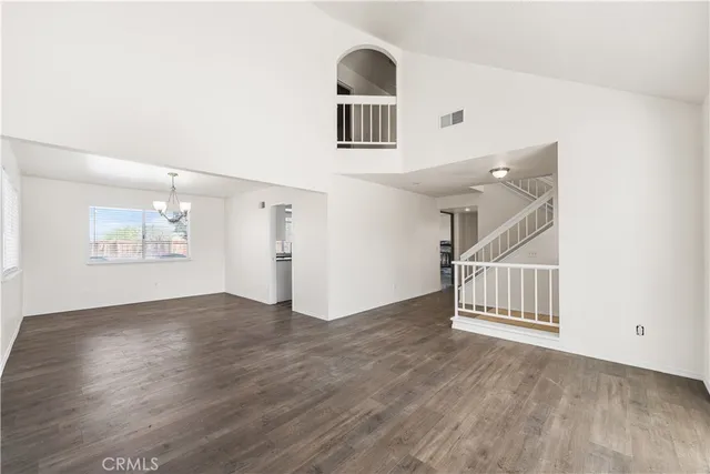 a view of a livingroom with wooden floor and stairs