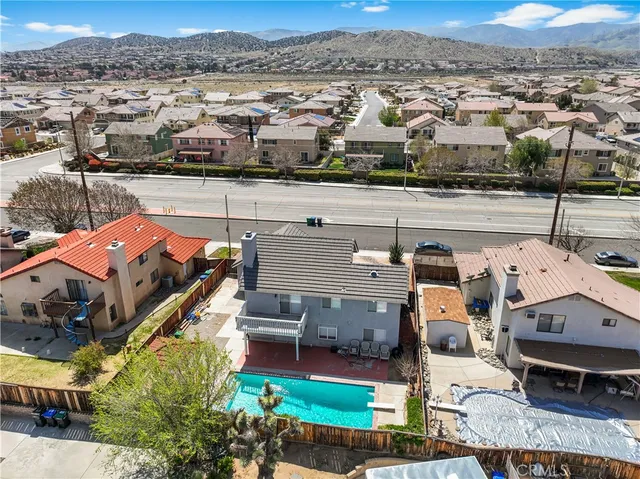 an aerial view of a house with a mountain