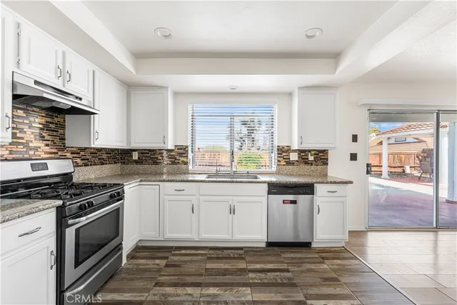 a kitchen with stainless steel appliances granite countertop a stove a sink and a refrigerator