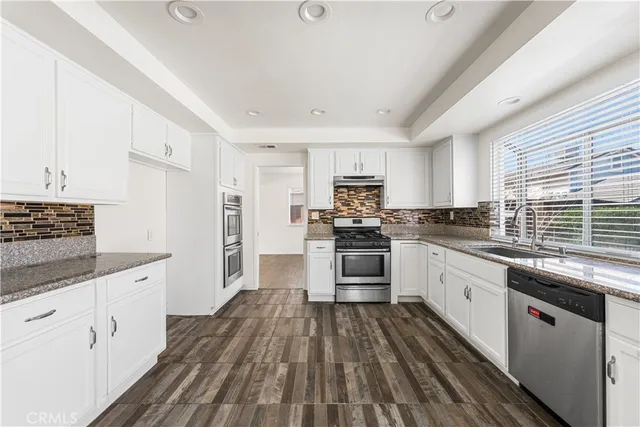 a kitchen with granite countertop appliances cabinets and a sink