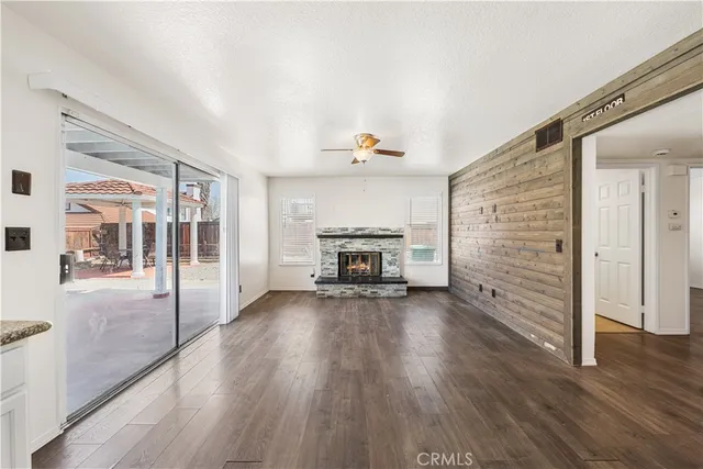 a view of a livingroom with wooden floor a fireplace and window
