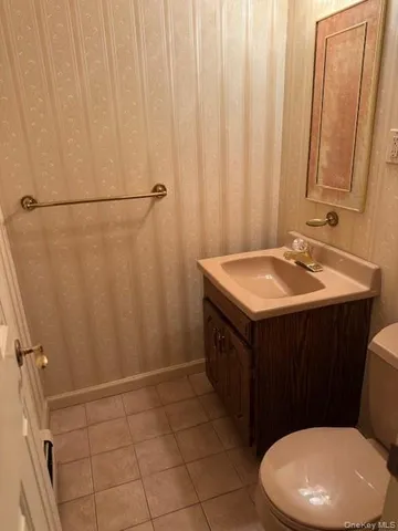 a bathroom with a sink a toilet a mirror and shower curtain