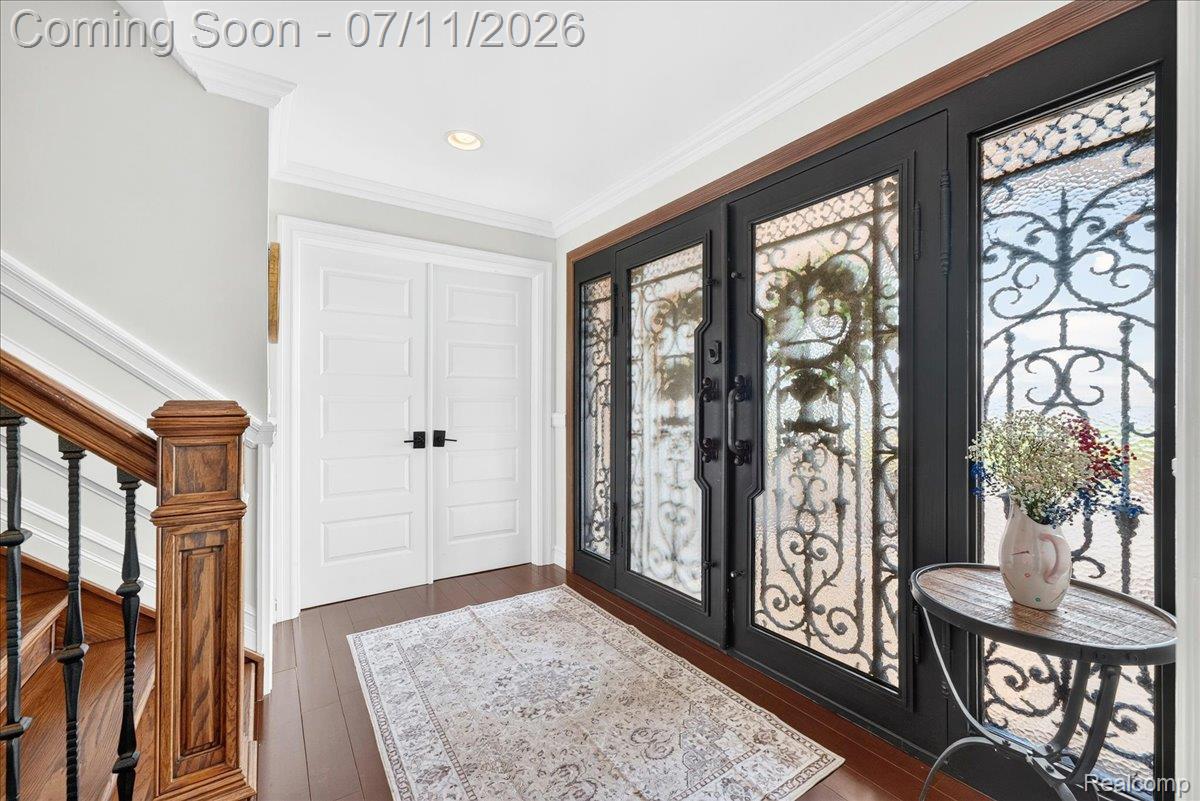 23750 East River Road Grosse Ile, MI 48138 - Photo 5 of 54 Entryway featuring intricate wrought iron and glass double doors, wood-finish flooring, recessed lighting, and a hardwood staircase with wrought iron balusters