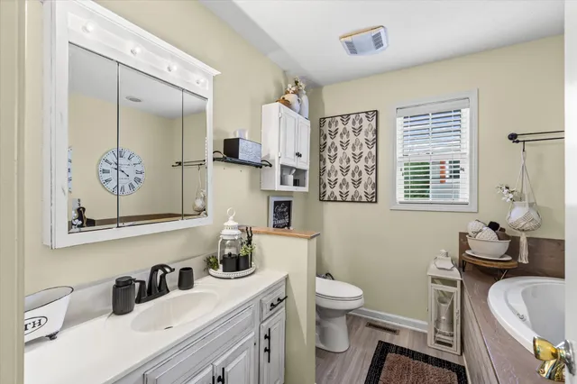 a bathroom with a sink a toilet a mirror and shower