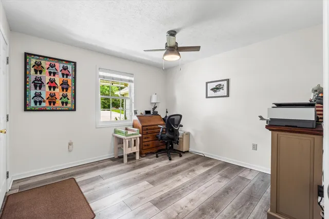 a view of a workspace with furniture and a window