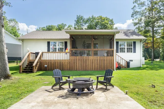 a view of a chair and table in backyard of the house