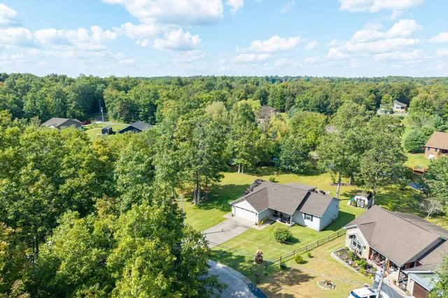 an aerial view of lake residential house with outdoor space and trees all around