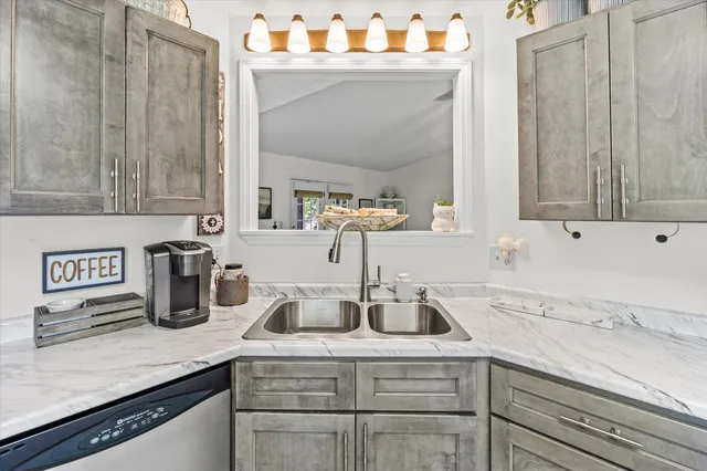 a kitchen with granite countertop a sink stainless steel appliances and cabinets