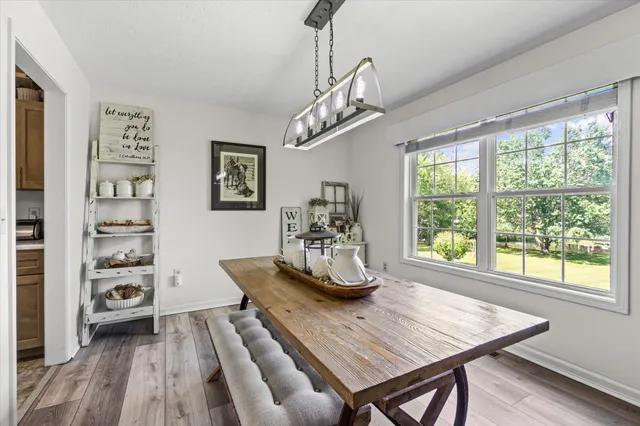a dining room with wooden floor and a chandelier