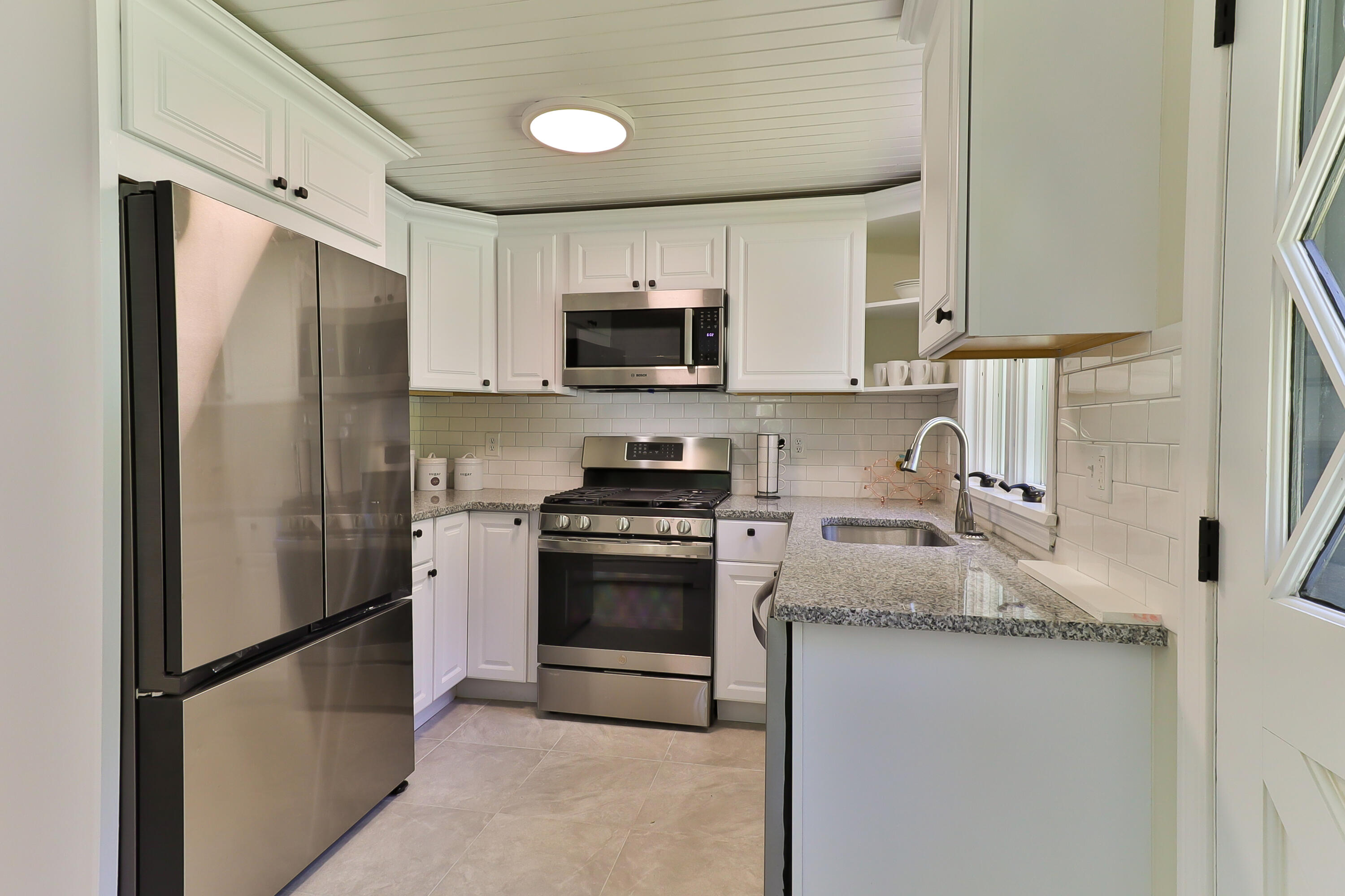 138 Lumbert Mill Road Centerville, MA 02632 - Photo 6 of 29 a kitchen with stainless steel appliances granite countertop a refrigerator a stove a sink and a microwave