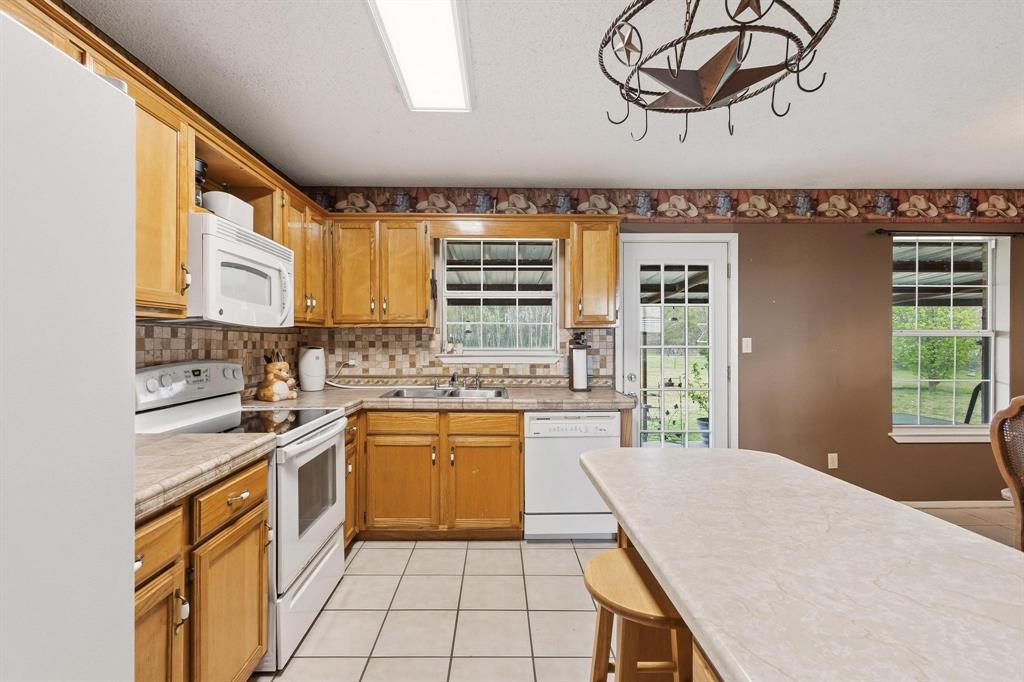 472 Milton-Minter Road Deport, TX 75435 - Photo 12 of 30 a kitchen with stainless steel appliances granite countertop a sink dishwasher stove and refrigerator