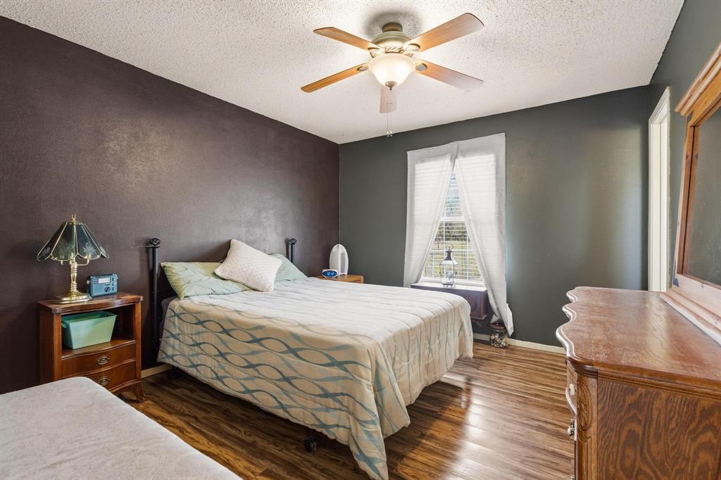 472 Milton-Minter Road Deport, TX 75435 - Photo 14 of 30 a bedroom with a bed and a chandelier