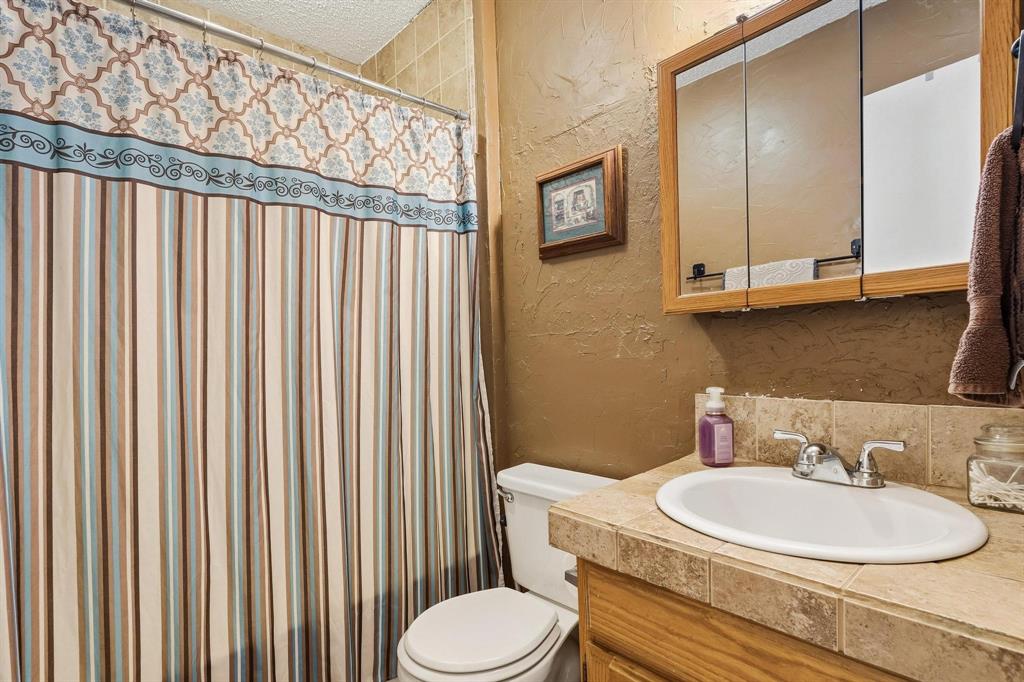 472 Milton-Minter Road Deport, TX 75435 - Photo 18 of 30 a bathroom with a toilet a sink and a mirror