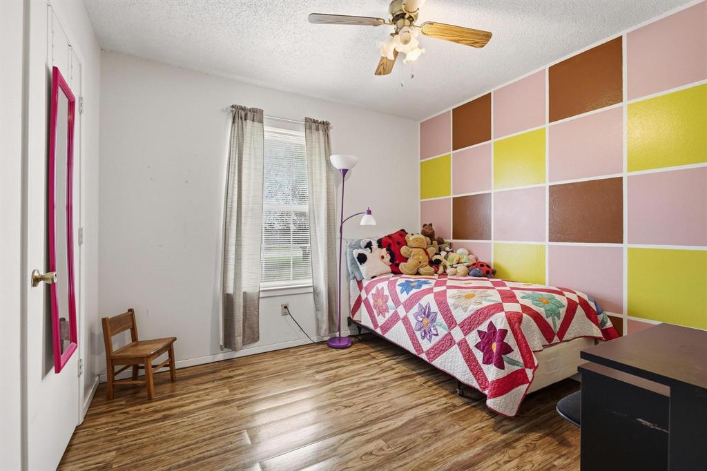 472 Milton-Minter Road Deport, TX 75435 - Photo 19 of 30 a bedroom with a bed and wooden floor