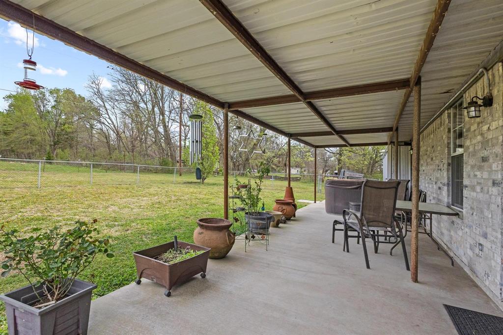 472 Milton-Minter Road Deport, TX 75435 - Photo 22 of 30 a view of a patio with chairs and table under an umbrella