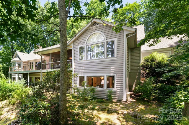 a view of a house with a small yard plants and large tree
