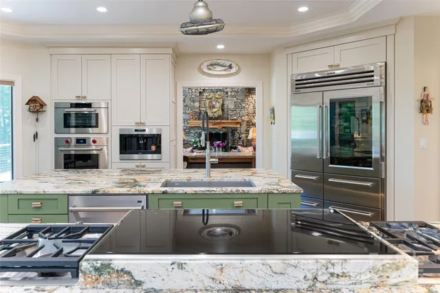 a kitchen with stainless steel appliances kitchen island granite countertop a stove and a sink