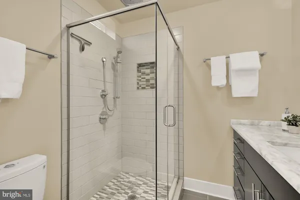 a bathroom with a granite countertop shower sink and toilet