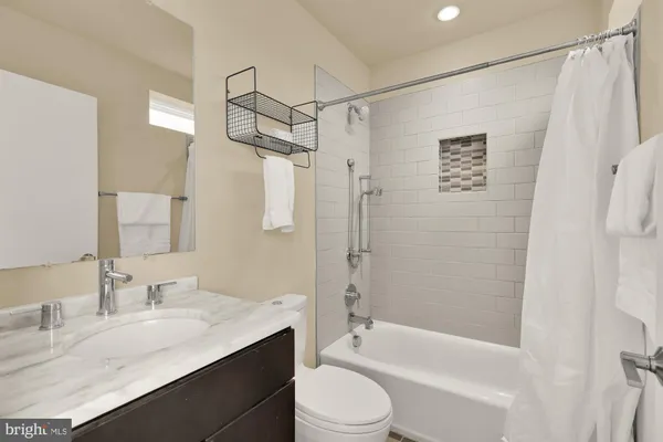 a bathroom with a granite countertop sink mirror toilet and shower