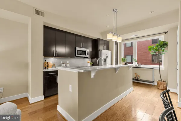 a kitchen with kitchen island a counter top space appliances and cabinets