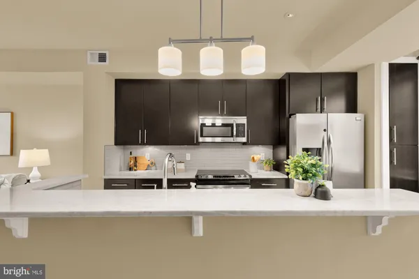 a kitchen with a refrigerator a sink and cabinets