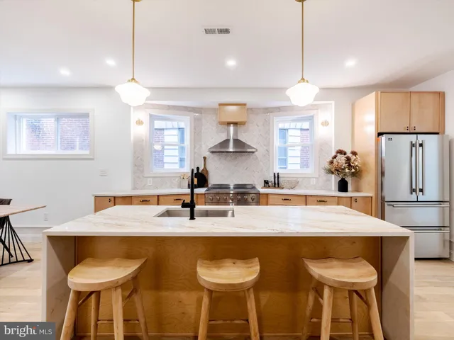 a kitchen with granite countertop a table chairs stove and refrigerator
