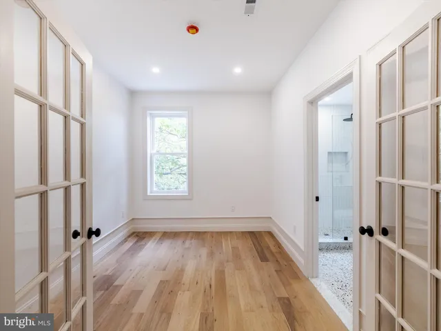 a view of a hallway with wooden floor and staircase