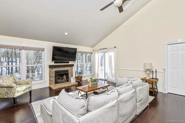 a living room with furniture fireplace and a large window