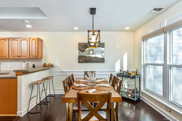 a kitchen with stainless steel appliances granite countertop a refrigerator a stove top oven a sink dishwasher and white cabinets with wooden floor