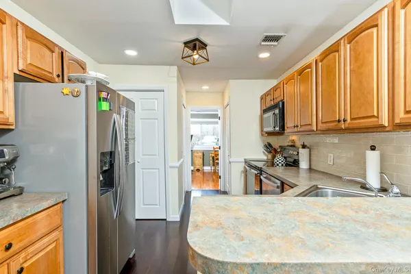 a kitchen with stainless steel appliances granite countertop a sink stove and microwave