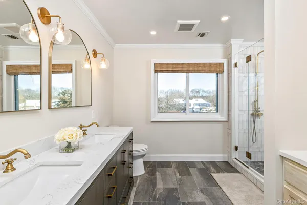 a bathroom with a granite countertop sink mirror and a toilet