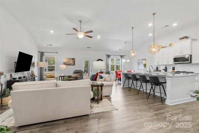 a living room with furniture kitchen view and a flat screen tv