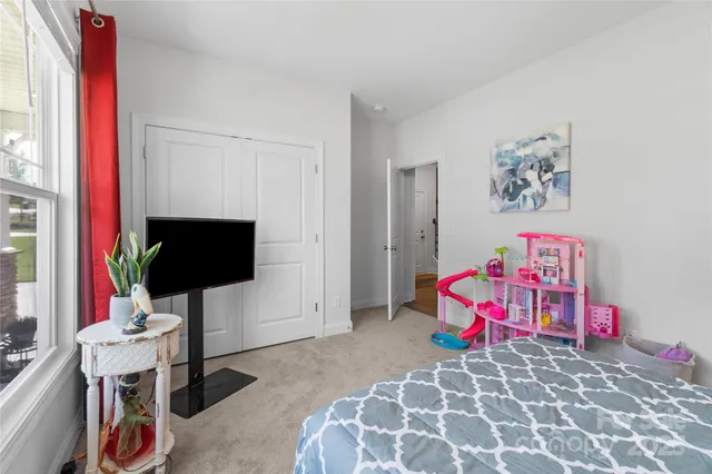 a bedroom with furniture and a flat screen tv