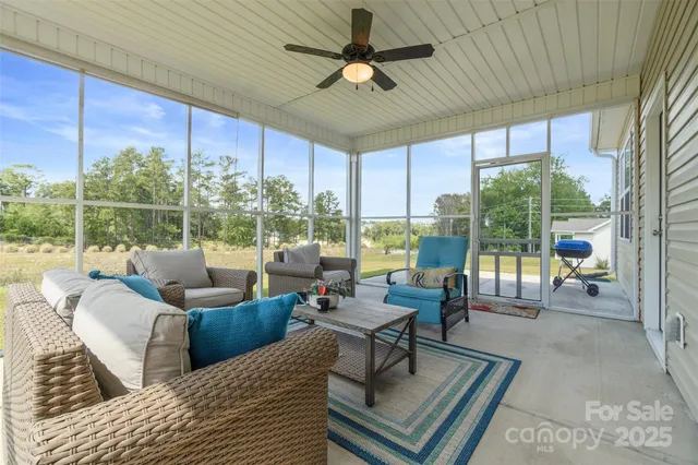 a living room with furniture and a floor to ceiling window