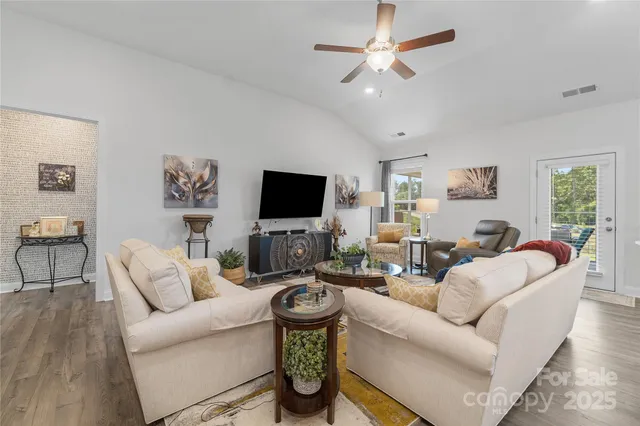 a living room with furniture a flat screen tv and a wall painting