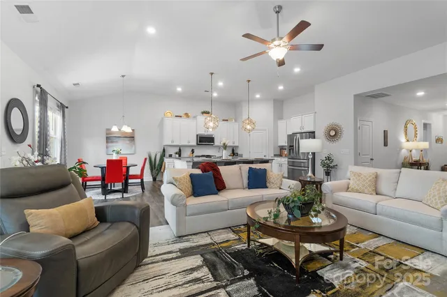a living room with furniture kitchen view and a table