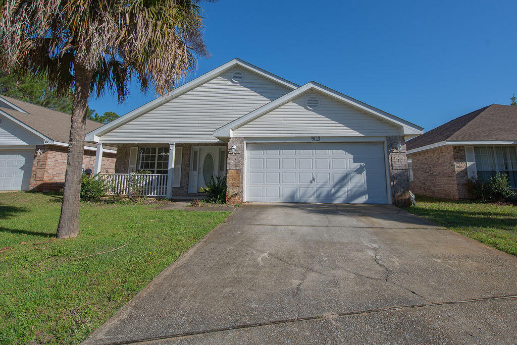 a view of a house with a yard and palm trees
