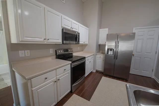 a kitchen with white cabinets stainless steel appliances and a sink