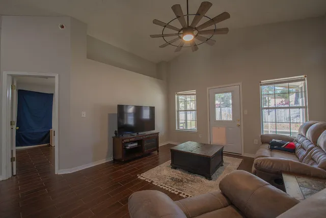 a living room with furniture a ceiling fan and a window
