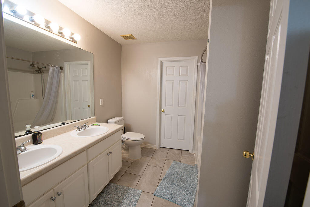 903 Lajolla Lane Mary Esther, FL 32569 - Photo 32 of 47 a bathroom with a double vanity sink and mirror with toilet
