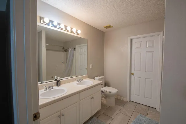a bathroom with a double vanity sink and a mirror
