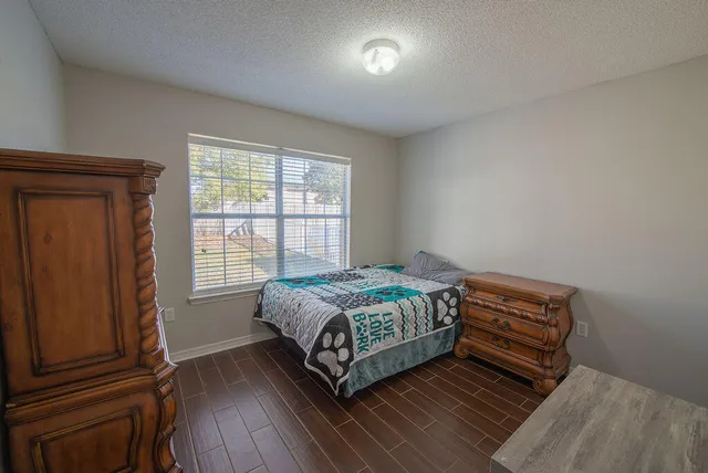 a bedroom with a bed and wooden floor