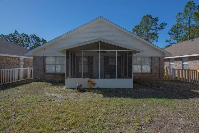 a view of a house with a yard and large tree